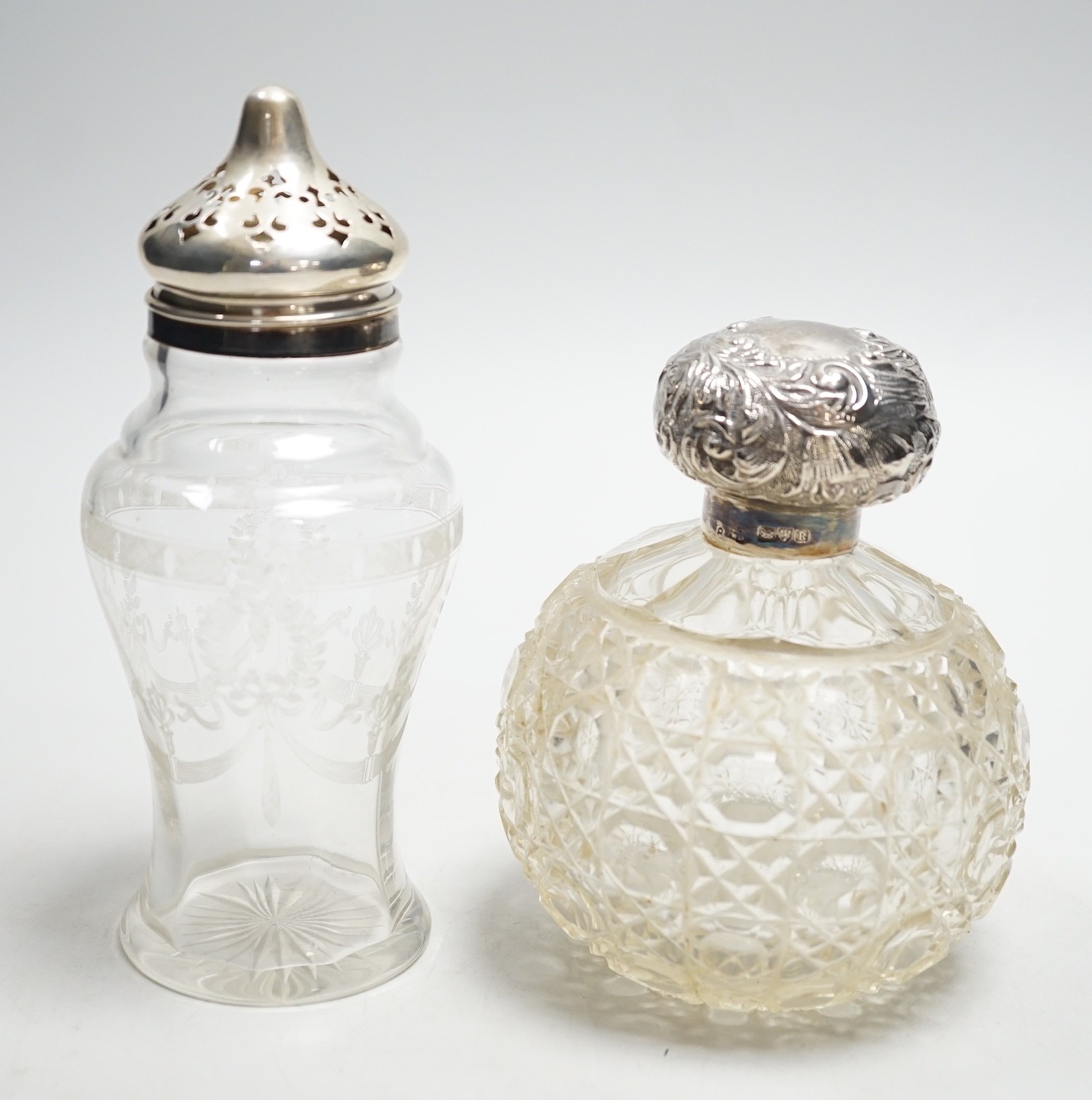 A late Victorian repousse silver mounted cut glass scent bottle, Chester, 1900, 13cm and a silver mounted sugar caster.